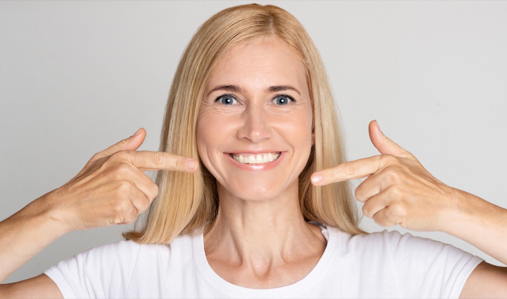 Strong,Healthy,Teeth.,Woman,Pointing,On,Her,Perfect,Smile,Over