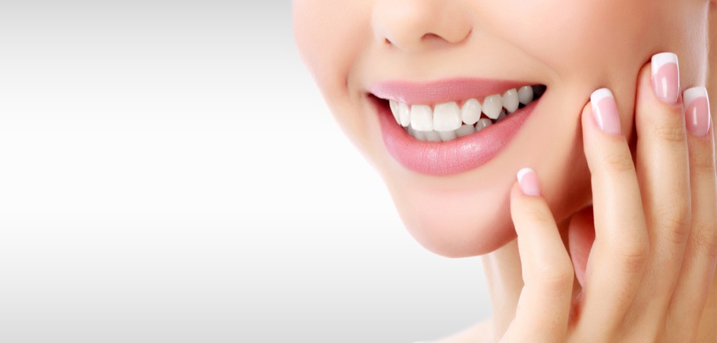 Closeup,Shot,Of,Woman’s,Toothy,Smile,Against,A,Grey,Background