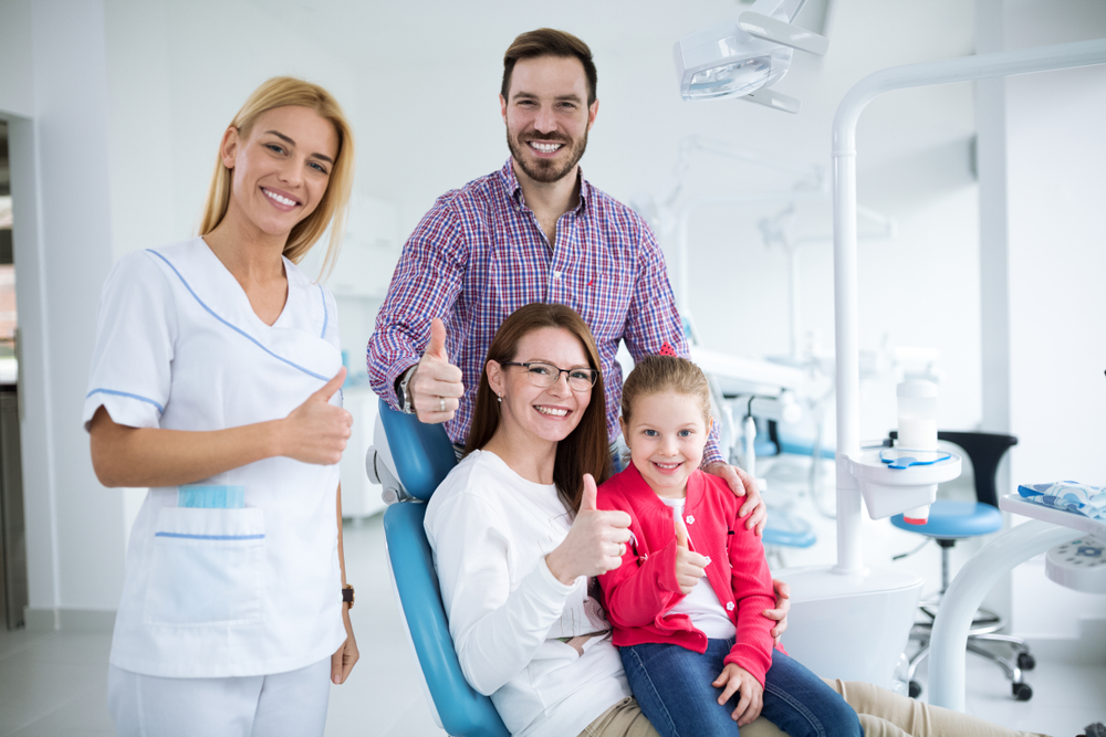 Happy,Family,With,A,Smiling,Young,Dentist,In,A,Dental