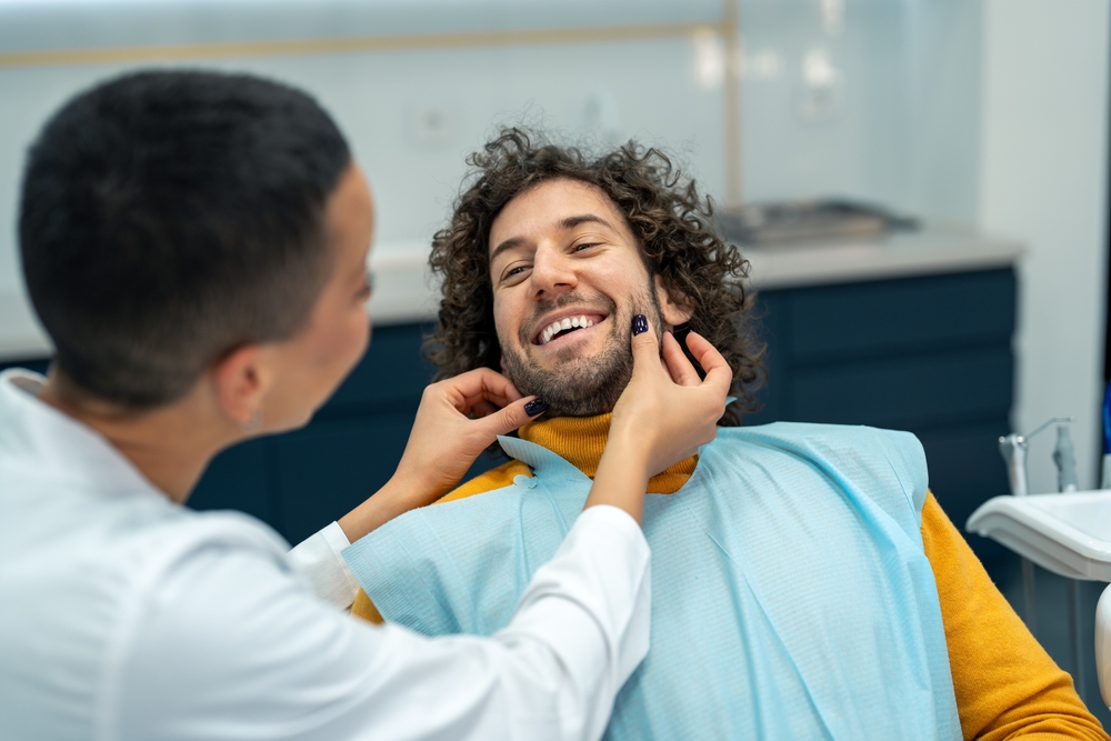 Smiling,Man,At,Dentist,Appointment.,Happy,Man,With,Curly,Hair